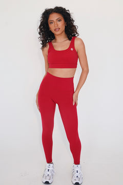 Woman wearing a red athletic outfit on a white background
